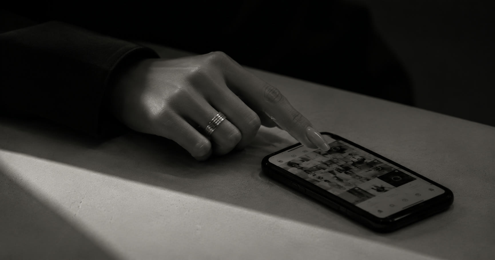 A hand scrolling a curated Instagram grid on a phone.