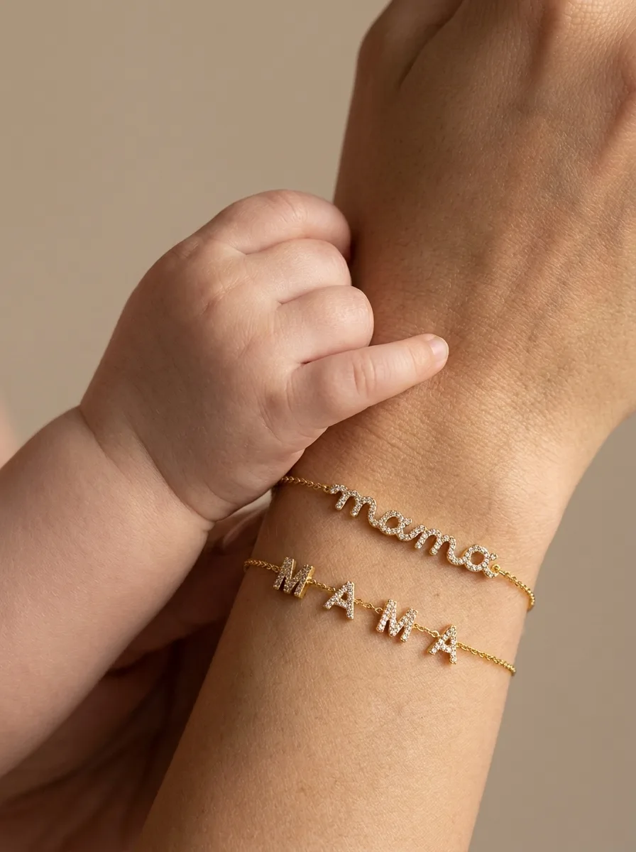 A baby’s fist beside a mother’s arm wearing mama and MAMA bracelets