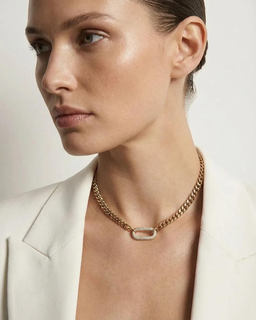 Model in a white blazer wearing a chain necklace